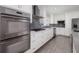 White kitchen with stainless steel appliances and gray tile backsplash at 3931 38Th S Way, St Petersburg, FL 33711