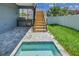 Backyard with wooden stairs, small pool, and grassy area at 2200 Bay Blvd # A, Indian Rocks Beach, FL 33785