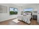 Bright bedroom with hardwood floors, a queen-size bed, and large windows with street view at 2200 Bay Blvd # A, Indian Rocks Beach, FL 33785