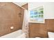 Clean bathroom with brown tile, shower, and window at 6490 34Th N Ave, St Petersburg, FL 33710