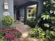 Inviting front porch with a bistro table nestled among vibrant flowers and plants at 10366 136Th St, Largo, FL 33774