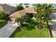 An aerial view showcasing a waterfront home with lush landscaping at 4 Treasure Ln, Treasure Island, FL 33706