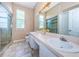 Spacious bathroom with double vanity, ample lighting, and glass-enclosed shower at 1032 Rosetree Ln, Tarpon Springs, FL 34689