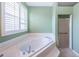 Bathroom featuring large garden tub with tile surround and glass enclosed shower at 1032 Rosetree Ln, Tarpon Springs, FL 34689