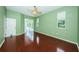 Bright bedroom features rich hardwood floors, ceiling fan, and glass sliding door to outdoor patio at 1032 Rosetree Ln, Tarpon Springs, FL 34689