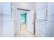 Walk-in closet with white shelving, drawers, and access to ensuite bath with tub and shower at 1032 Rosetree Ln, Tarpon Springs, FL 34689