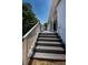 Wooden deck with white railing and columns leading to covered patio with ceiling fan at 1032 Rosetree Ln, Tarpon Springs, FL 34689