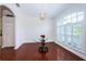Bright dining area featuring rich wood floors, elegant lighting, and large windows with plantation shutters at 1032 Rosetree Ln, Tarpon Springs, FL 34689