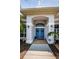 Elegant double front door with arched entryway, framed by lush landscaping and charming exterior lighting at 1032 Rosetree Ln, Tarpon Springs, FL 34689