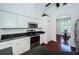 Modern kitchen with white cabinets, granite countertops, stainless steel appliances, and hardwood floors at 1032 Rosetree Ln, Tarpon Springs, FL 34689