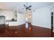 Open-concept living area with hardwood floors, seamlessly connecting the living room to the kitchen and front entrance at 1032 Rosetree Ln, Tarpon Springs, FL 34689