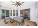 Inviting covered patio with modern outdoor furniture, ceiling fan, and multiple sliding glass doors at 1032 Rosetree Ln, Tarpon Springs, FL 34689