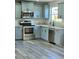 Modern kitchen featuring light blue cabinets, stainless steel appliances, and granite countertops at 1638 Polo Club Dr, Tarpon Springs, FL 34689