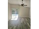 Bright living room featuring vinyl flooring and sliding glass doors at 1638 Polo Club Dr, Tarpon Springs, FL 34689