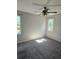 Spacious bedroom with ceiling fan, carpet, and large windows at 1638 Polo Club Dr, Tarpon Springs, FL 34689