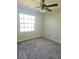 Bright bedroom with ceiling fan, carpet, and large window at 1638 Polo Club Dr, Tarpon Springs, FL 34689