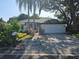 Single story home with white exterior and driveway at 1638 Polo Club Dr, Tarpon Springs, FL 34689