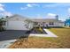 Single story home with white exterior and neutral landscaping at 910 Spindle Palm Way, Apollo Beach, FL 33572