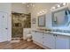 Bright bathroom featuring a glass shower, double vanity with granite countertops, and stylish lighting at 129 Brent Cir, Oldsmar, FL 34677