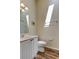 Bright bathroom with a wooden floor, white vanity and a convenient towel rack at 129 Brent Cir, Oldsmar, FL 34677
