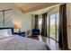 Bright bedroom features a comfortable bed, stylish decor, and sliding glass doors to the balcony at 129 Brent Cir, Oldsmar, FL 34677