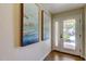 Entryway featuring hardwood floors, artwork and a glass front door that brings in lots of natural light at 129 Brent Cir, Oldsmar, FL 34677