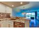 Modern kitchen featuring stainless steel appliances, granite countertops, and seamless flow to the living area at 129 Brent Cir, Oldsmar, FL 34677
