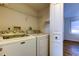Convenient laundry room featuring a full-size washer and dryer, shelving, and direct access to the bedroom at 129 Brent Cir, Oldsmar, FL 34677