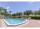 Outdoor community pool area featuring lounge chairs, mature trees and well-maintained landscaping on a sunny day at 129 Brent Cir, Oldsmar, FL 34677