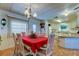 Charming dining room with a red tablecloth and chandelier, open to the kitchen at 402 Blue Marlin Dr, Oldsmar, FL 34677