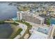 Aerial view of a waterfront condo complex, featuring a pool, beach, and surrounding waterways at 6035 Sea Ranch Dr # 505, Hudson, FL 34667