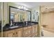 Bathroom with dual sinks, black granite counters, and walk-in shower with clear glass doors at 6035 Sea Ranch Dr # 505, Hudson, FL 34667