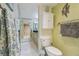 Bright bathroom features a toilet and cabinet with mirrored closet doors and decorative fish art on the light green walls at 6035 Sea Ranch Dr # 505, Hudson, FL 34667