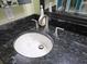 Bathroom sink with a polished dark granite countertop and stainless steel faucet at 6035 Sea Ranch Dr # 505, Hudson, FL 34667