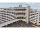 Multi-story condo building featuring covered parking, a welcoming entrance and manicured landscaping at 6035 Sea Ranch Dr # 505, Hudson, FL 34667