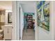 Hallway view of the bathroom leading to a bedroom with a bookcase and sailing painting at 6035 Sea Ranch Dr # 505, Hudson, FL 34667