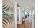 Hallway view into a condo unit showcasing wood-look flooring and views of the den and living areas at 6035 Sea Ranch Dr # 505, Hudson, FL 34667