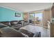 Comfortable living room with a leather sofa, wood flooring, and a sliding glass door to the balcony at 6035 Sea Ranch Dr # 505, Hudson, FL 34667