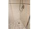 Close up of beige tiled shower featuring pebble flooring and a handheld shower head at 6035 Sea Ranch Dr # 505, Hudson, FL 34667