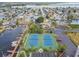Aerial view of two meticulously maintained tennis courts, lush landscaping and reserved parking at 6035 Sea Ranch Dr # 505, Hudson, FL 34667