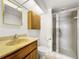 Bathroom featuring wood cabinets, a shower, and a gold-trimmed mirror at 830 S Gulfview Blvd # 305, Clearwater Beach, FL 33767