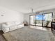 Bright living room with large sliding glass doors to a balcony and plush carpet at 830 S Gulfview Blvd # 305, Clearwater Beach, FL 33767