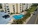 An elevated view showcases a community pool, parking lot, and condo building at 830 S Gulfview Blvd # 305, Clearwater Beach, FL 33767