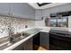Kitchen features gray cabinets, stainless steel sink, and mosaic backsplash at 1750 Harbor S Pl # 103, South Pasadena, FL 33707