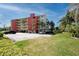 Condominium building with parking and lush green space at 1750 Harbor S Pl # 103, South Pasadena, FL 33707