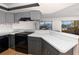 Modern kitchen with gray cabinets, glass countertops, and a water view at 1750 Harbor S Pl # 103, South Pasadena, FL 33707