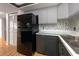 Kitchen features black appliances and gray cabinets at 1750 Harbor S Pl # 103, South Pasadena, FL 33707