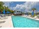 Community pool with patio furniture and umbrellas at 1750 Harbor S Pl # 103, South Pasadena, FL 33707
