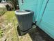 Exterior shot of an air conditioning unit against a teal wall at 5060 86Th Ave N, Pinellas Park, FL 33782