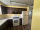 Kitchen area with white appliances and dark brown cabinets at 5060 86Th Ave N, Pinellas Park, FL 33782